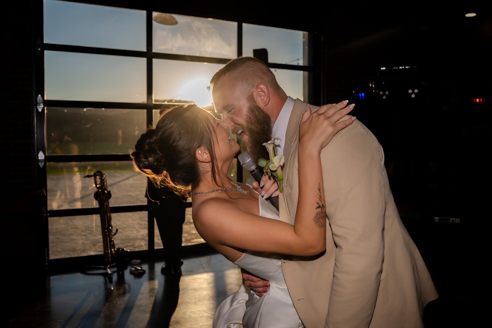 Newlyweds laughing and singing together into a microphone at their reception
