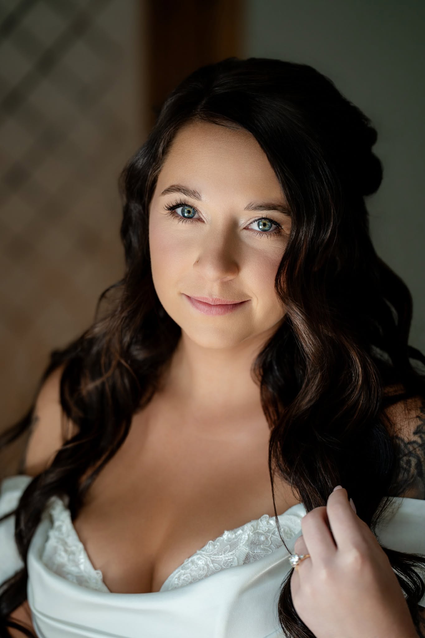 Close portrait of a bride with dark curls and a ring on her hand
